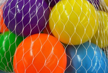 Beyaz bir çantada renkli toplar.