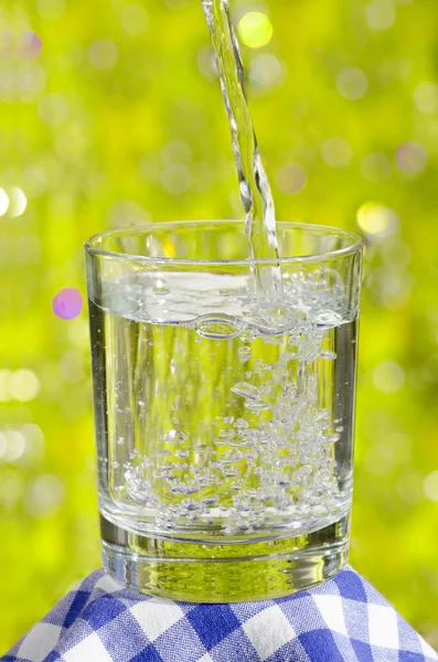 Glas Wasser auf Naturhintergrund. — Stockfoto