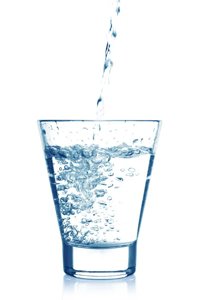 Helder water wordt gegoten in een glas beker geïsoleerd op witte achtergrond — Stockfoto