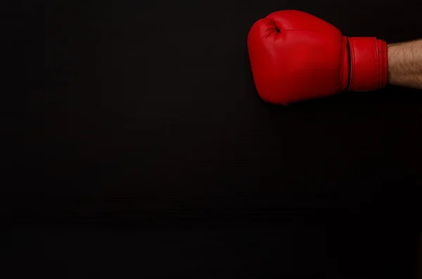 Hand in red boxing gloves on a black background empty space. — Stok fotoğraf