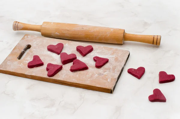 Wooden board with red hearts made of dough. Valentine's day — Stok fotoğraf