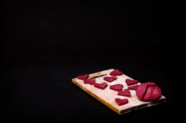Red heart-shaped cookies on a wooden plank, baking the day of Valentine's — Stok fotoğraf