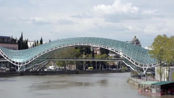 Ponte da Paz em Tbilisi, junto ao rio Kura, o movimento de carros na estrada — Vídeo de Stock