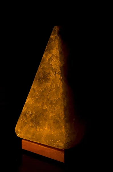 Salt lamp in the form of a pyramid in the darkness — Stock Photo, Image