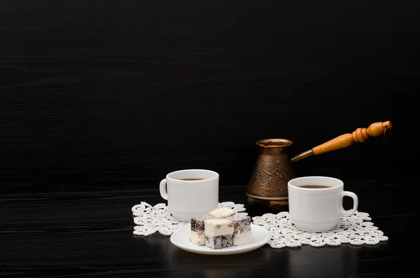 Two cups of coffee on white napkins, pots and Turkish sweets on a black background. Space for text — Stock Photo, Image