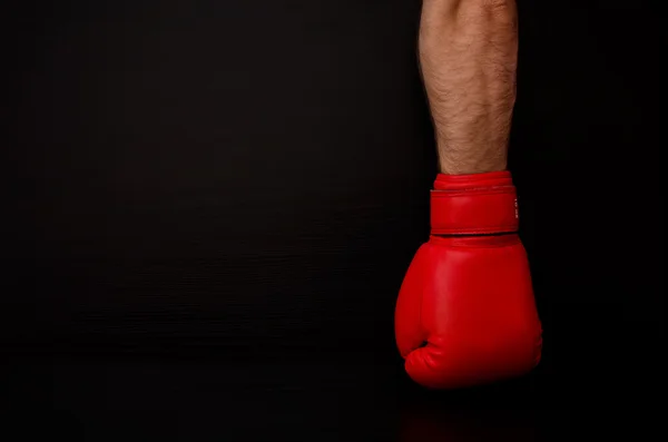 Two hands in red boxing gloves in the side of the frame on a black background,  empty space — Zdjęcie stockowe