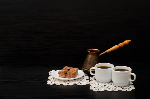 Side view of two cups of coffee on the lace napkins, chocolate dessert and Turkish pots — Stock Photo, Image