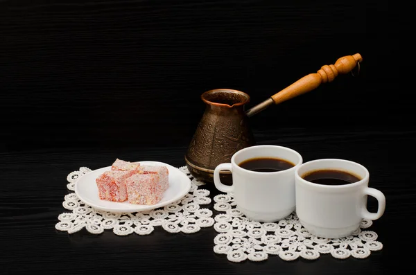 Two cups of coffee on the lace napkins, pots and  turkish dessert on a black background — Stock Photo, Image