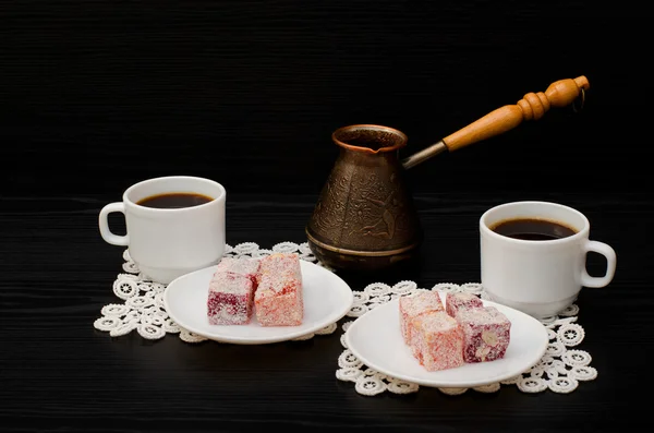 Cezve, colorful Turkish Delight and two cups of coffee on the lace napkins black background — Stock Photo, Image