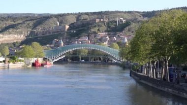 Kura Nehri manzarası, dünyanın cam köprüsü, teleferik ve Narikala Kalesi. Yolda hareket arabaları. Tiflis