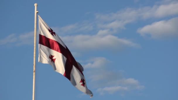 Georgië vlag op de vlaggenmast zwaaiende in de achtergrond van de bewolkte hemel — Stockvideo
