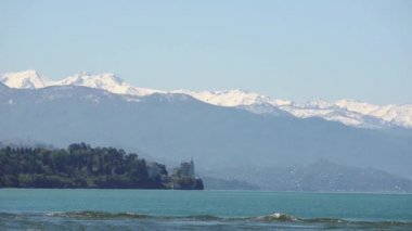 Deniz manzarası, yemyeşil tepeler ve karla kaplı dağlar. Karadeniz, Gürcistan.