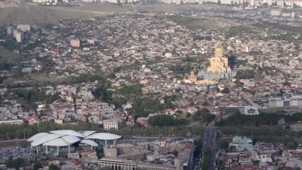 Tiflis con la altura del Monte Mtatsminda, Catedral de la Trinidad de Sameba, Casa de Justicia, barrios residenciales, el tráfico — Vídeo de stock