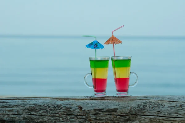 Twee cocktails op een logboek op de achtergrond van de avond zee, ruimte voor tekst — Stockfoto