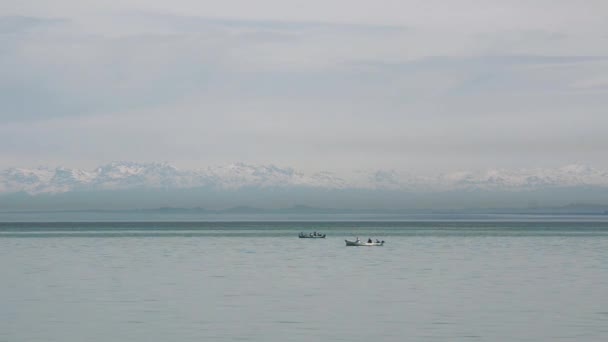 Två båtar drift på bakgrund av snöklädda berg. Svarta havet Batumi, Georgien. — Stockvideo