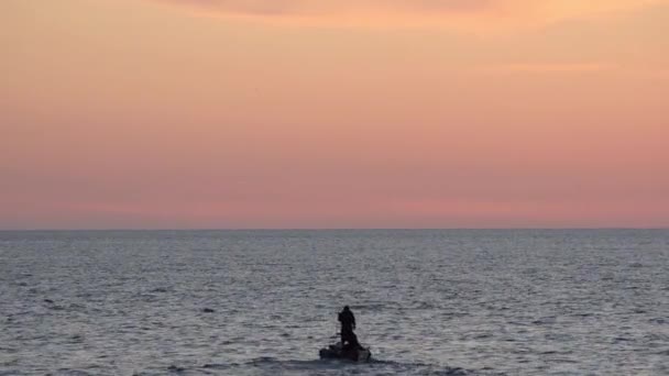 在船上的渔民把网扔进大海在落日的天空背景 — 图库视频影像