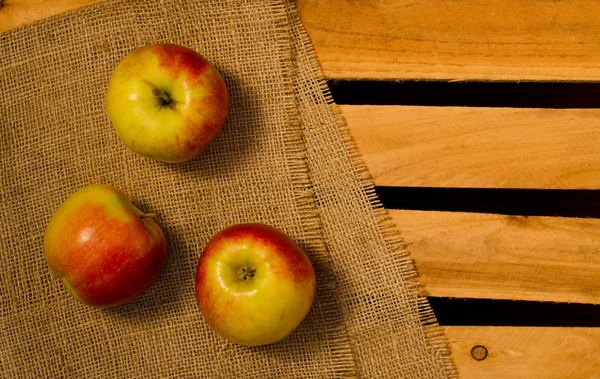 Спелые яблоки на мешковину и деревянные тарелки, место для текста, вид сверху — стоковое фото
