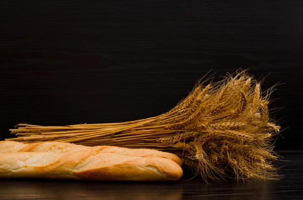 Pão e pães brancos sobre fundo preto, com espaço para texto — Fotografia de Stock