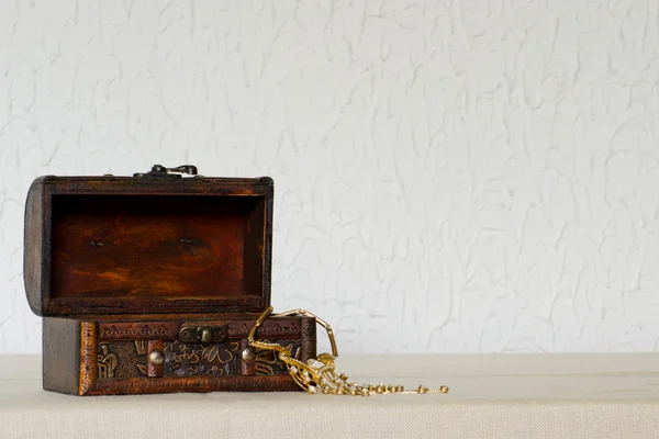 Boîte à bijoux vintage en bois ouverte avec un collier sur fond blanc — Photo