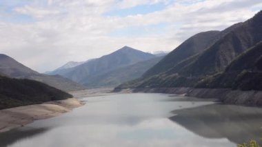 Geniş nehir manzarası, bulutlar ve mavi gökyüzü arka plan üzerinde yemyeşil dağlarla çevrili. Zhinvali depo, nehir Aragvi, Georgia, Caucasus.