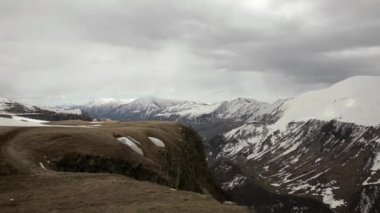 Plato görünümü, vadi ve karla kaplı dağlar kalın karanlık bulutlar arka planda. Georgia, Caucasus.