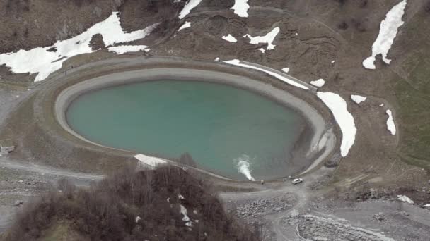 Bovenaanzicht van het stuwmeer in de bergen in het voorjaar. Close-up. Georgia, Caucasus. — Stockvideo