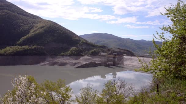 Zobrazit na vodní elektrárna obklopené zelenými horami na pozadí mraků a modrá obloha. Žinvalská přehradní nádrž, řeka Aragvi, Gruzie, Kavkaz. — Stock video