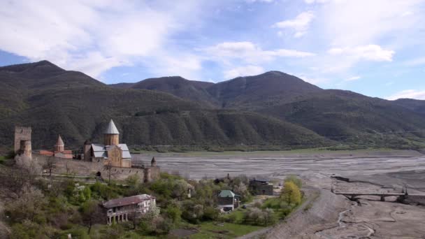 Ver fortaleza de Ananuri en el fondo no profundo río, montañas verdes primavera. Georgia, Cáucaso . — Vídeo de stock