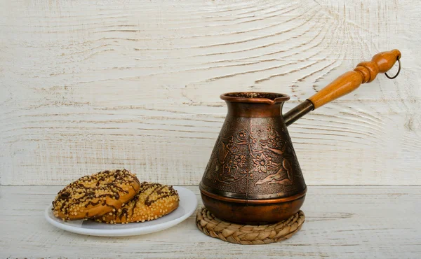 Cezve and cookies on a light wooden background — Stock Photo, Image