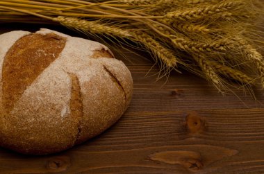 Çavdar ekmeği ve buğday ahşap bir masa üzerinde kulakları yuvarlak yakın çekim