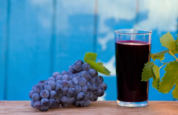 Glass of fresh grape juice, a bunch of grapes in the sunlight in the yard — Stock Photo, Image