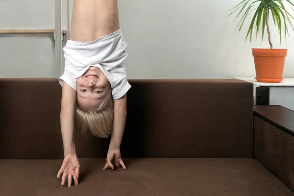 Pojken Upp Och Ner Över Soffan Roliga Barn Hänger Upp — Stockfoto