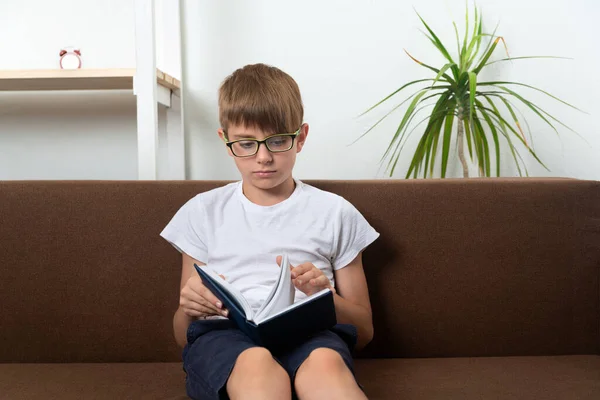 Teenager Sitzt Auf Couch Und Liest Buch Hausaufgabenbetreuung Hausaufgaben — Stockfoto