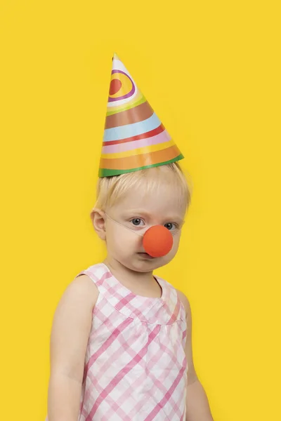 Parti Şapkalı Sarı Arka Planda Kırmızı Palyaço Burunlu Komik Kız — Stok fotoğraf