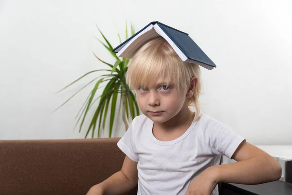 Blonder Junge Sitzt Mit Buch Auf Dem Kopf Wütender Kleiner — Stockfoto