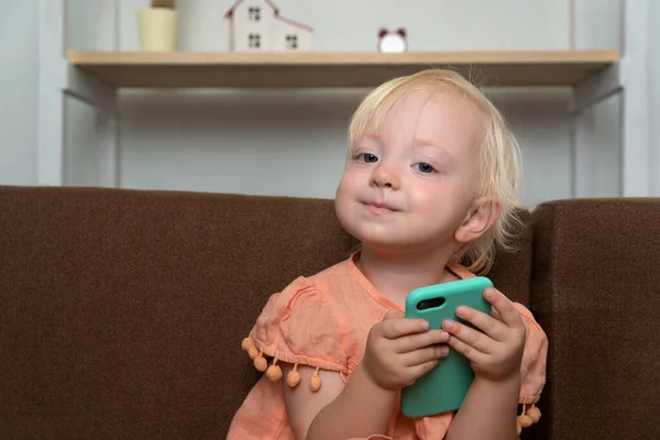幸せな赤ん坊は彼女の手に電話を持っている スマホを手にした子供の肖像 — ストック写真