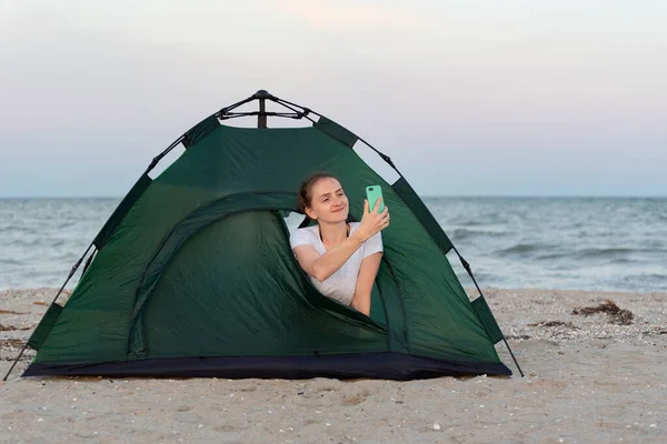 Улыбающаяся Молодая Женщина Палатке Берегу Моря Фотография Смартфоне — стоковое фото