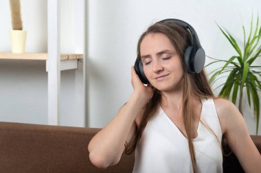 Kablosuz kulaklıklı genç kadın müzikten hoşlanıyor.