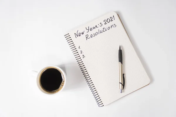 在笔记本和笔上写下2021年新年的决心 一杯咖啡放在桌上 — 图库照片