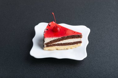 Beyaz tabakta vişneli kokteyl. Siyah arka planda lezzetli bir tatlı