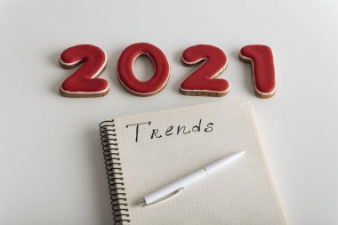 2021 rakamları ve beyaz arkaplanda yazı olan bir defter. Yeni yılda moda trendleri.