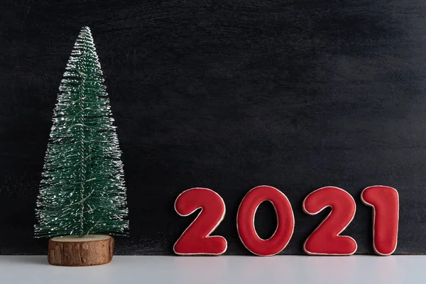人工的なクリスマスツリーと黒の背景に赤い数字2021 新年のコンセプト スペースのコピー — ストック写真