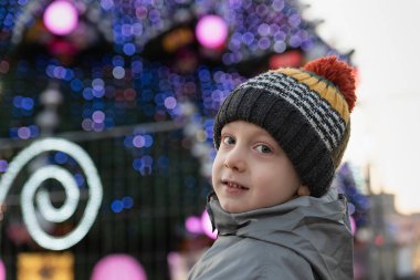 Noel ağacı arka planında şapkalı bir çocuğun portresi. Noel için hazırlanılıyor.