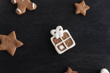 Siyah arka planda zencefilli çöreğin hediye kutusu ve yıldızları.