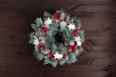 Koyu ahşap arka planda Noel çelenginin en üst görüntüsü. Boşluğu kopyala