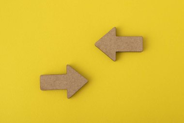 Sarı arka planda iki tahta ok. Yön işaretleri. Uzayı kopyala Model.