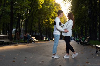 Park randevusu. Erkek ve kız parkta sarılıyorlar.