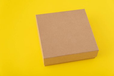 Sarı arka planda kare karton kutu. Uzayı kopyala Model