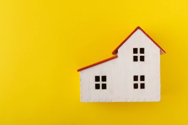 Sarı arka planda ev modeli. Oyuncak evi. Mülk. Özel mülk