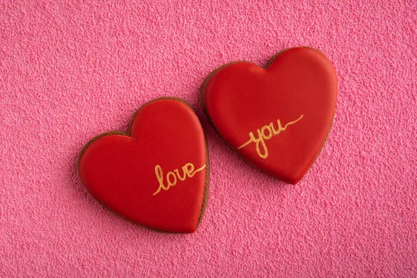 Два Красных Печенья Форме Сердец Надписью Любовь Розовом Фоне — стоковое фото